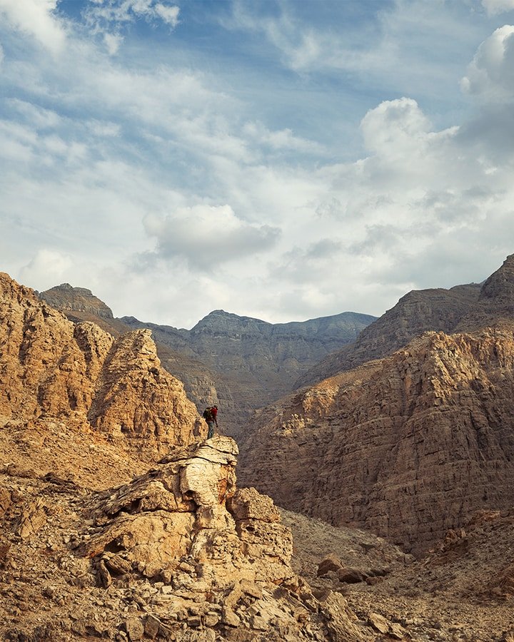 uae mountains in ras al khaimah and a man standing on the rock