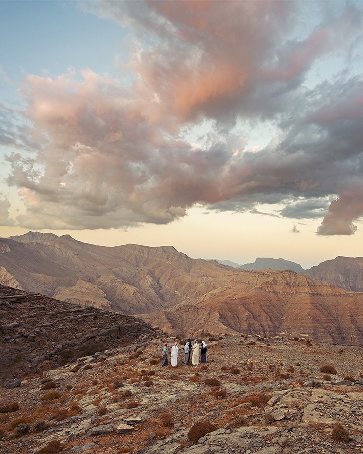 Cloudy Sunset at the top of the UAE mountains with a group of men standing