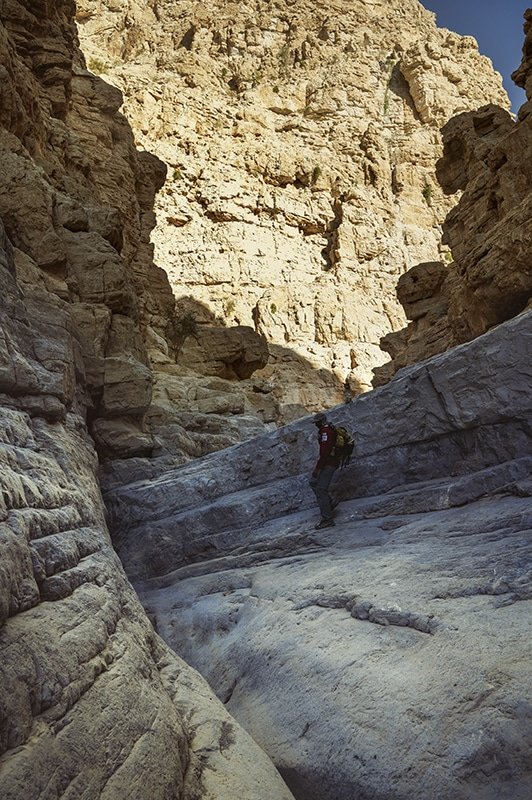 a man with a backpack in the gorge in wadi naqab uae
