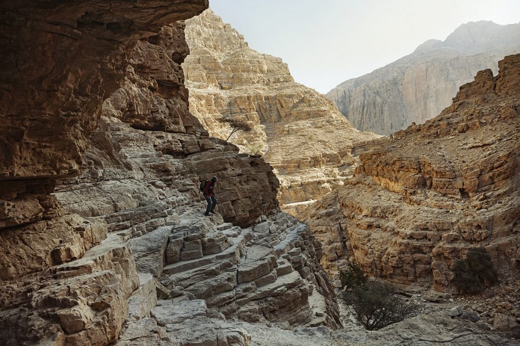 a man hiking on the ledges of the rocky mountains