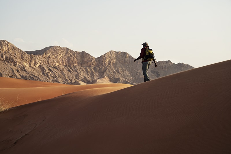 orange dunes of mleiha overlooking al faya mountain range- guide to mleiha sharjah uae