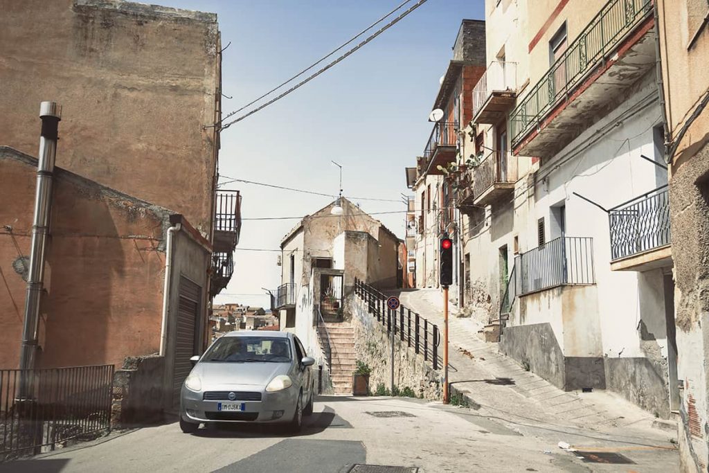 small trafic light in narrow street in sicily mountain town- sicily driving tips