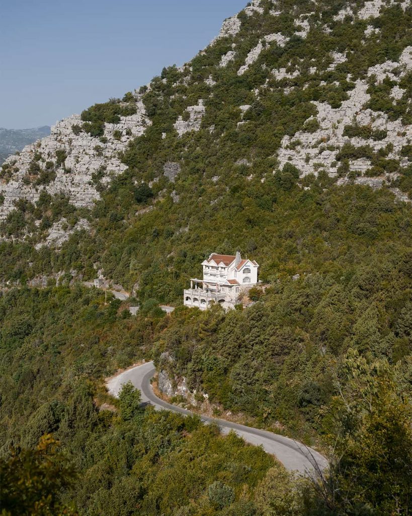 narrow countryside road in pavlova strana with abandoned hotel in montenegro