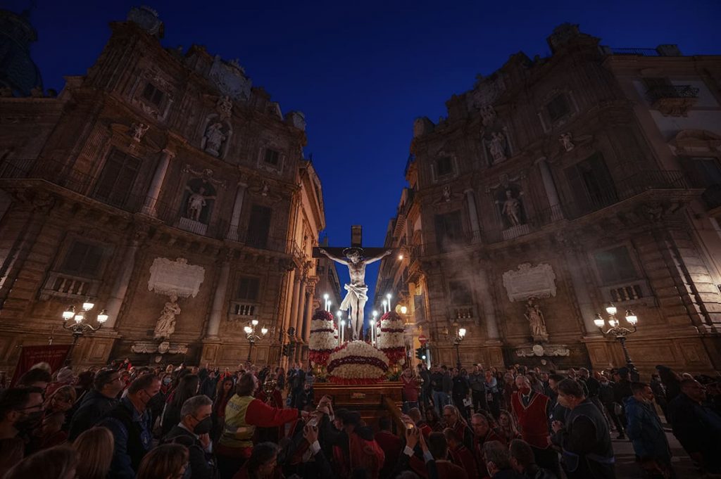 a statue of Chris being carried in Palermo historic center at night in Sicily