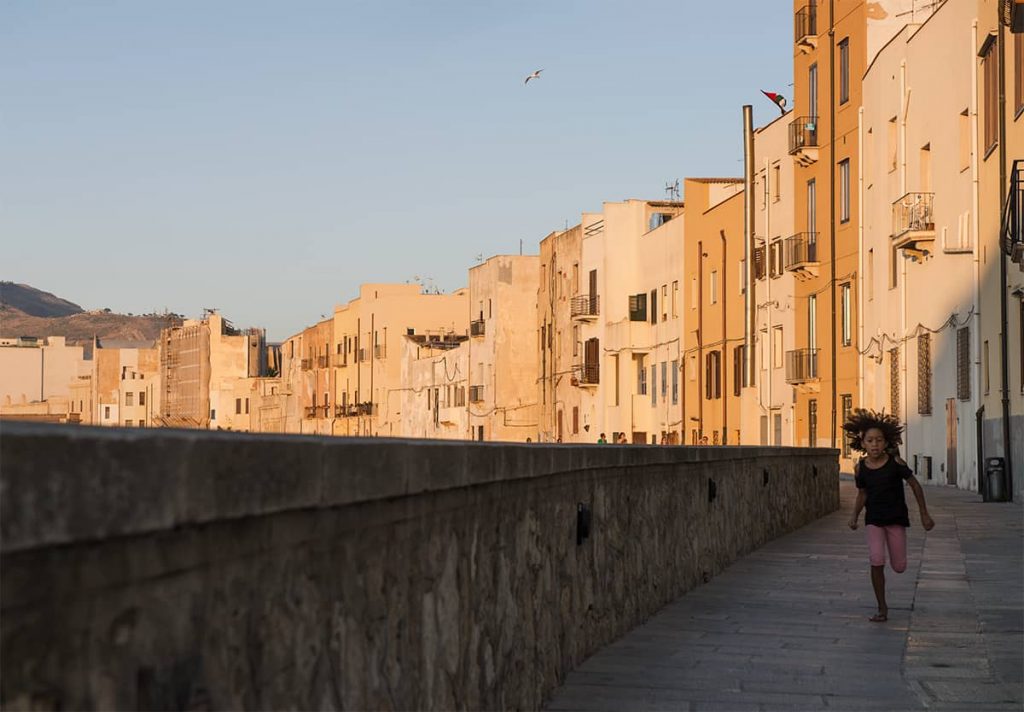 a girl running at sunset in trapani waterfront, siciyly