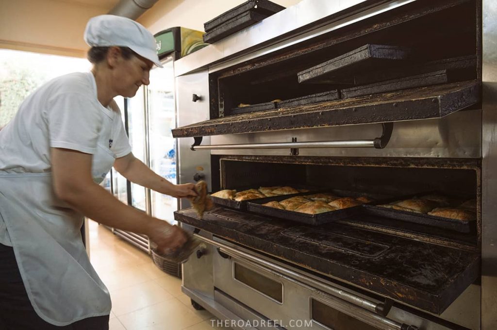 Byrek Te Castit shop- lady pulling out freshly baked byrek