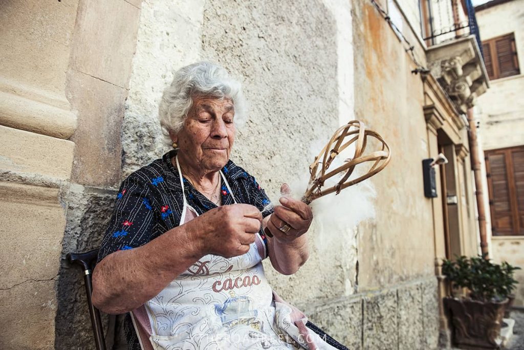 An elderly lady working on tapestry preparation in Madonie mountain village in Sicily
