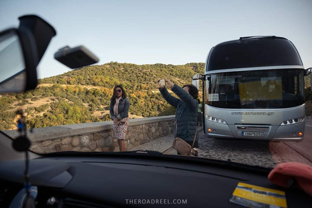 Looking at tourists stepping out their tour bus in Meteora