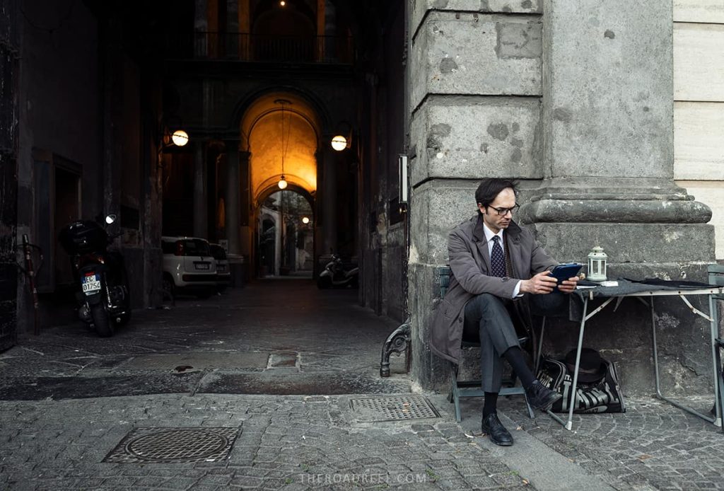 A man sitting at the coffee table Outside Gran Cafe Gambrinus, Naples itinerary