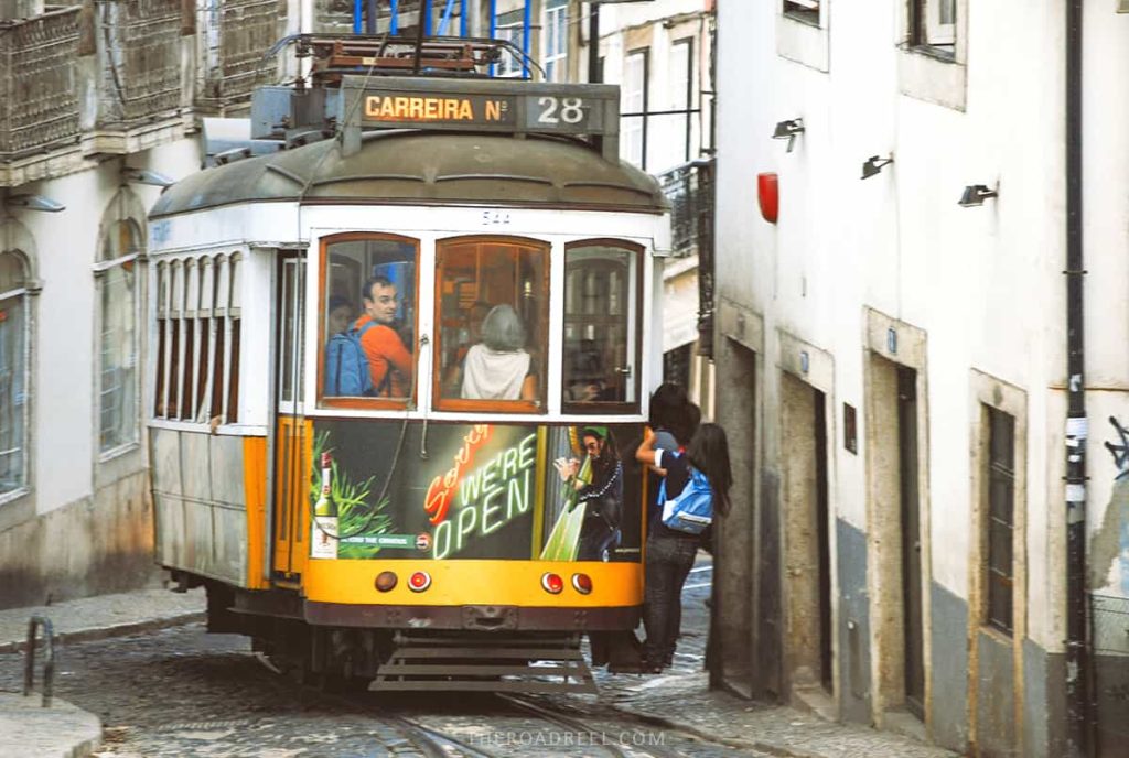 The popular tram 28 in Lisbon is one of the most fun things to do, girls outside are riding it for free.