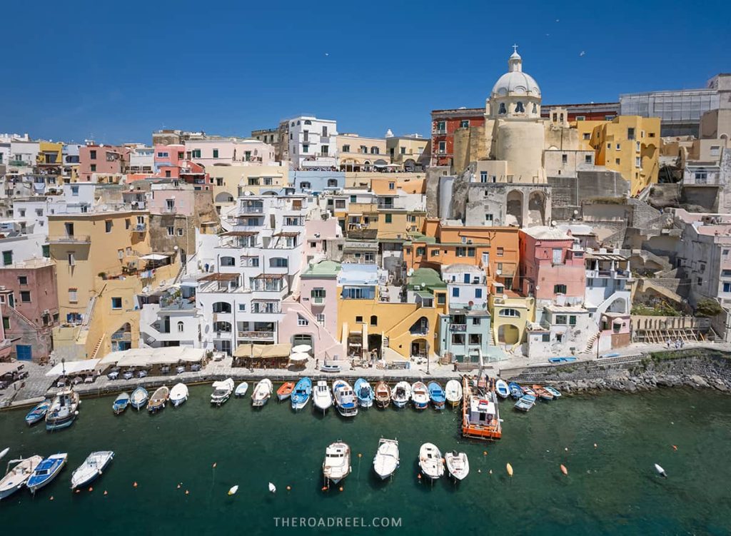 The cheerful Marina di Corricella harbor is the most beautiful place in Procida Island, Italy, drone image