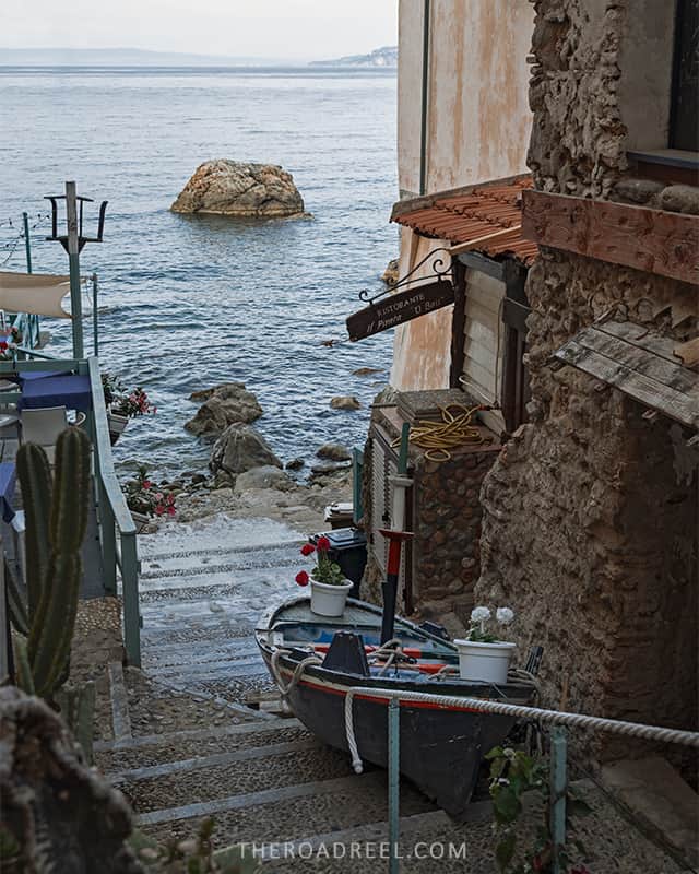 chianalea in scilla- narrow alleyway leading to water with a wooden boat parked- south italy itinerary