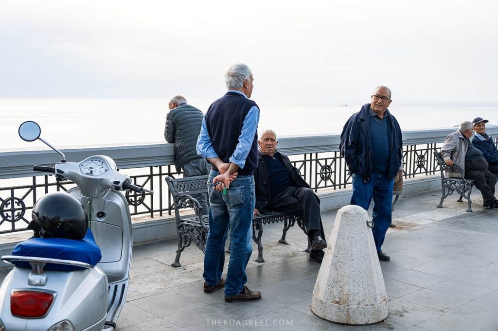 Men gathering at Piazza San Rocco, Scilla, Italy