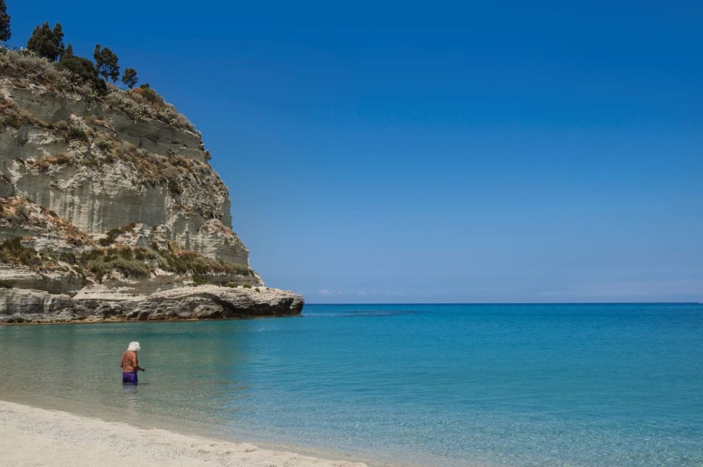 calabria travel tips- best time to visit- a man entering the water in tropea