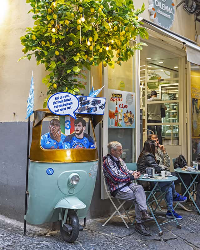 food is one of the reasons to visit naples- street cafe at quartieri spagnoli, with tuk tuk decoration