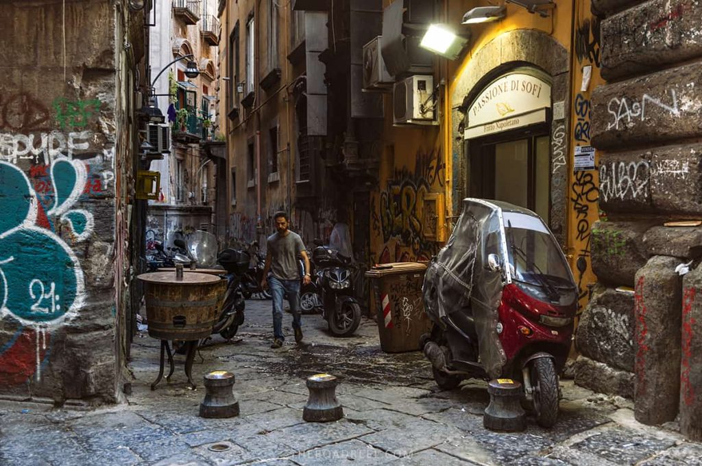 gritty streets of naples with graffiti on the walls