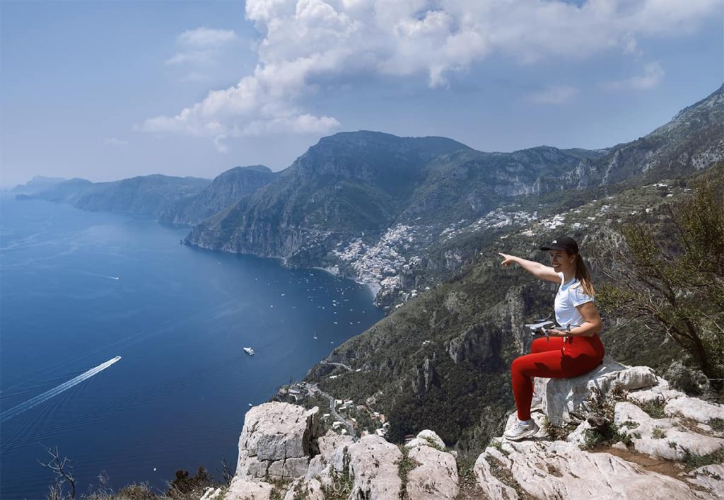 path gods hike, woman sitting on the rook looking towards the vast views over amalfi coast and positano