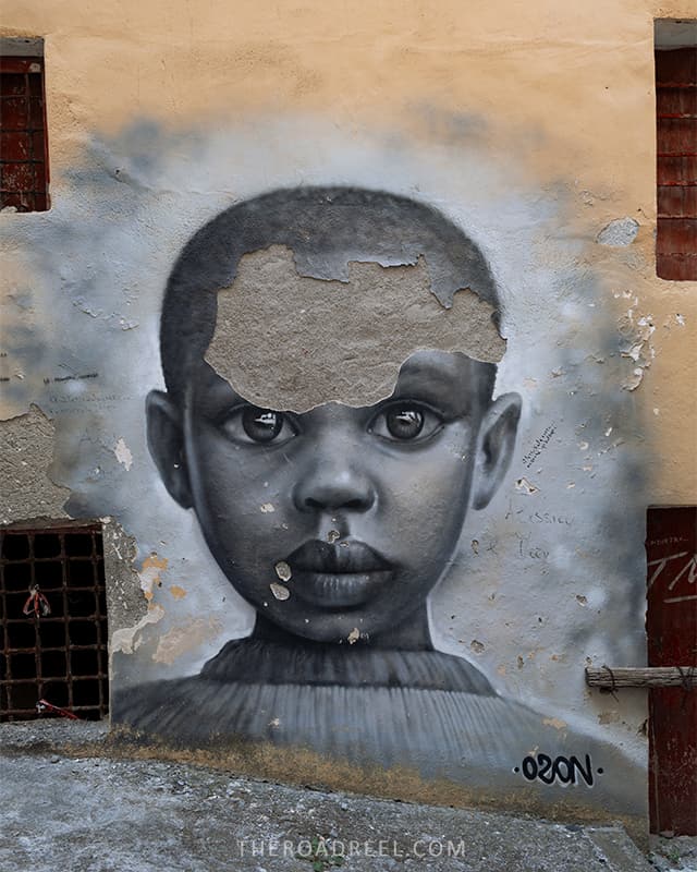 a mural of an african child on a wall in Diamante seaside town in Calabria, Italy