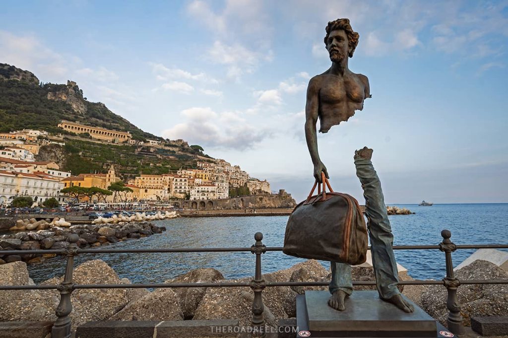 amalfi town- a bronze sculpture of a man holding a suitcase with optical illution