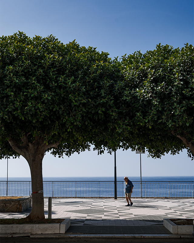 an elderly man walking along lungomare in diamante calabria